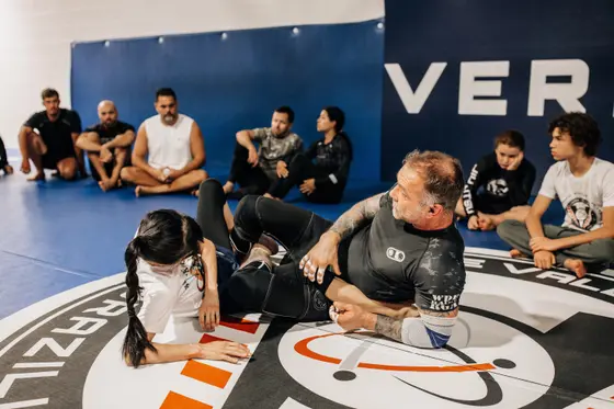 Seminar instruction with students watching on the mat